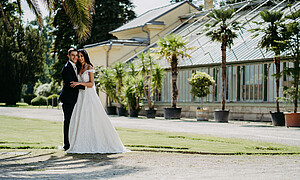 Brautpaar stehend vor der Orangerie im Schlosspark