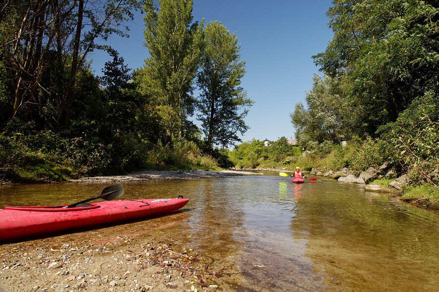 Flacher, ruhger Fluss mit rotem Kanu