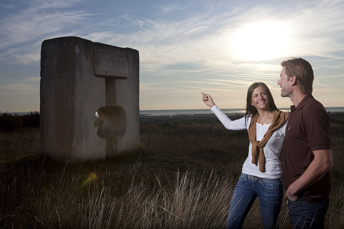 Ein Mann und eine Frau stehen vor einer Steinskulptur im Freien