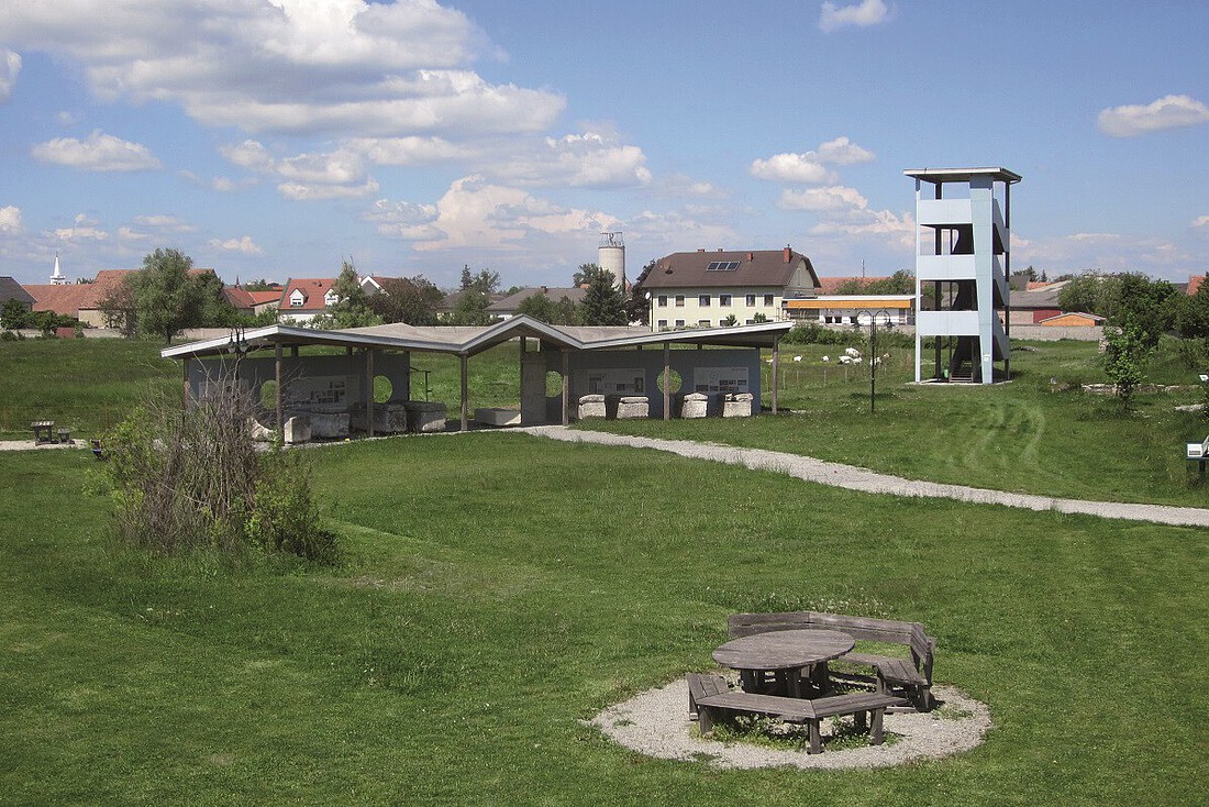 Aussichtsturm aus Metall und Informationstafeln auf einer Wiese