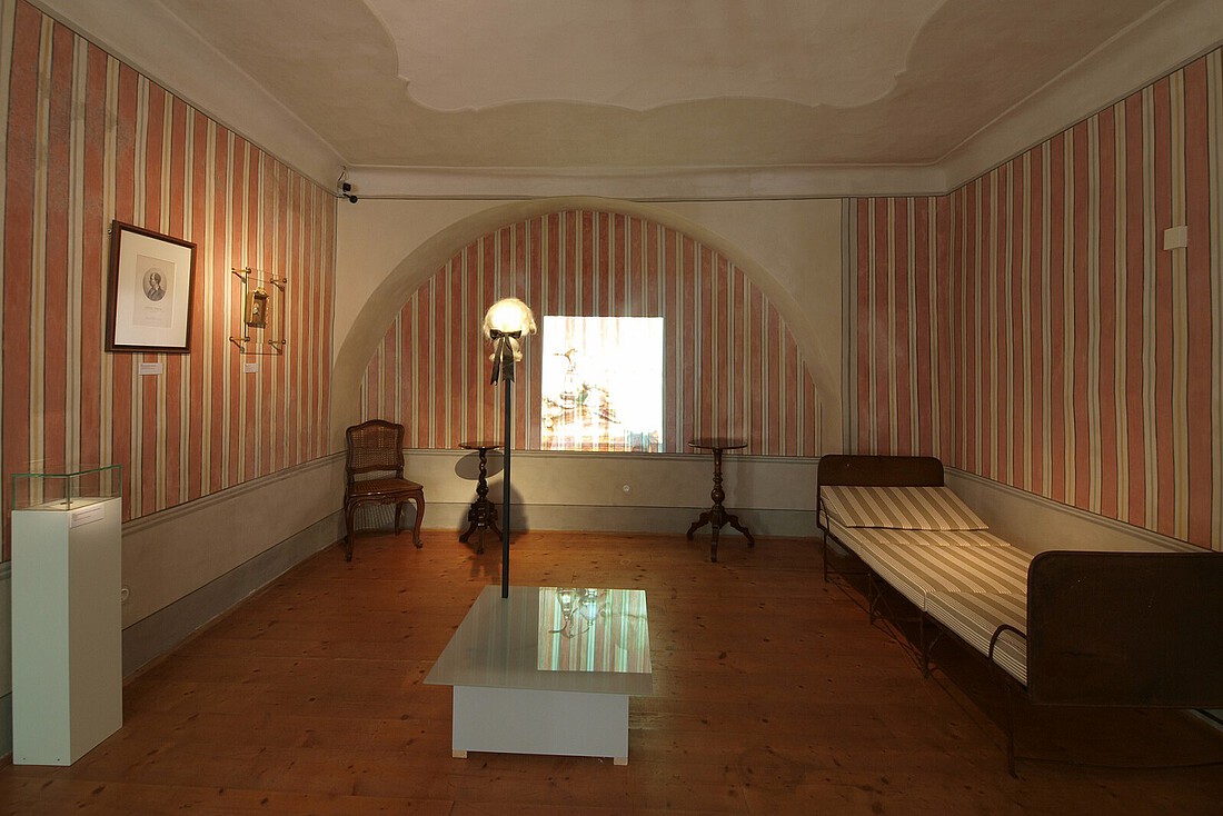 Historisches, im Barockstil eingerichtete Schalfzimmer mit rot-weißer Streifenmalrei an den Wänden