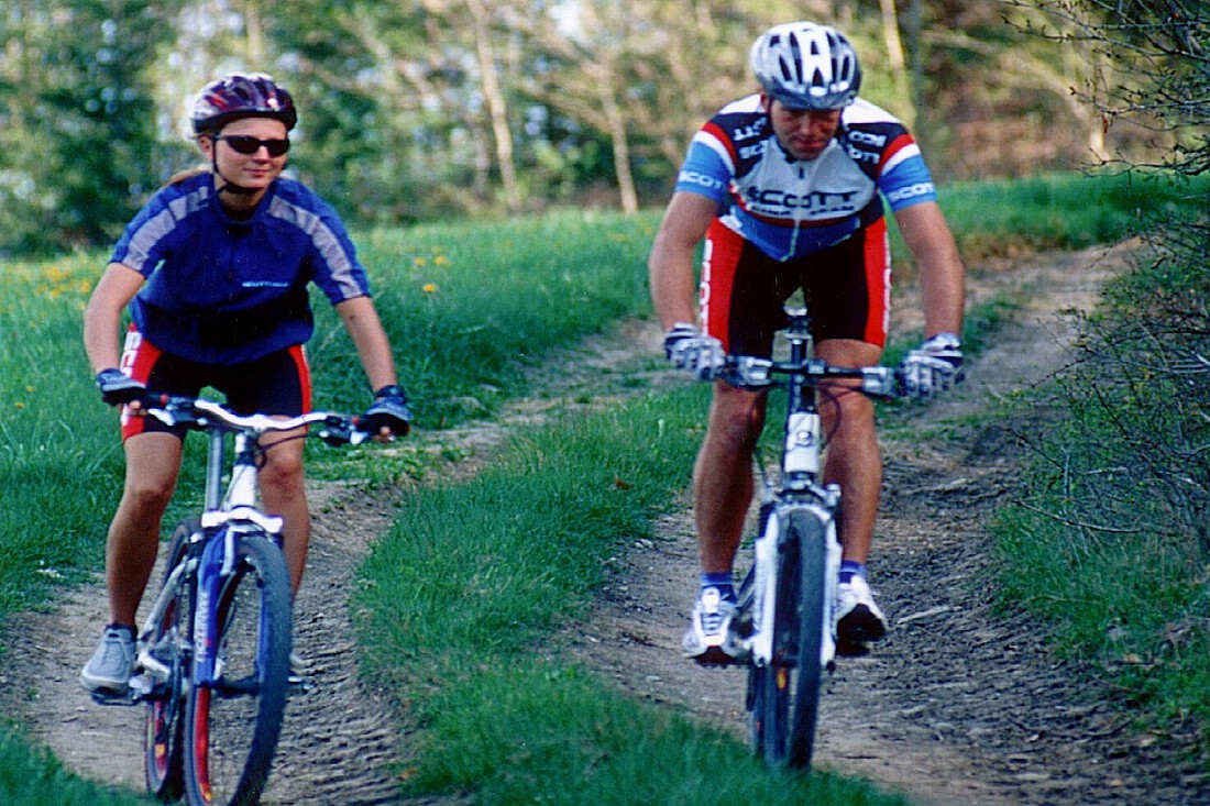 Ein Mann und eine Frau auf Mountainbikes auf einer Waldstrecke