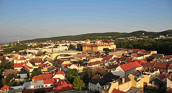 Luftaufnahme einer Stadt mit barockem, gelben Schloss.