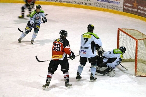 Fünf Eishockeyspieler auf einer Eisfläche vor dem Tor