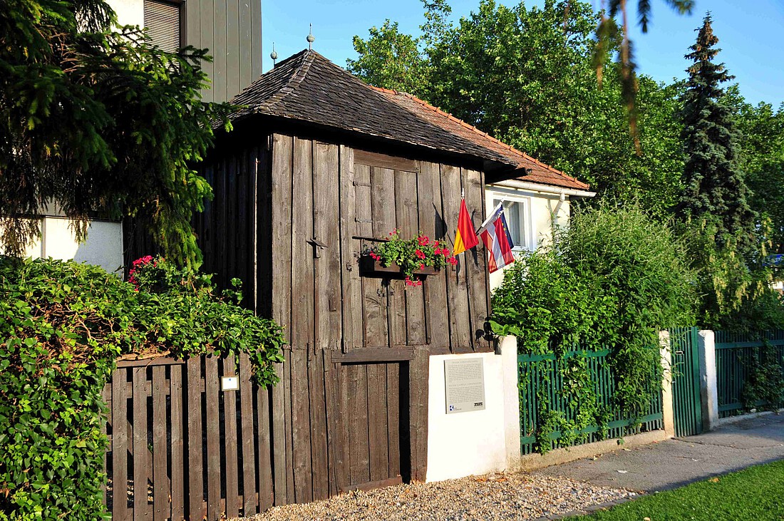 Kleines, sehr altes Gartenhäuschen aus dunklem Holz.