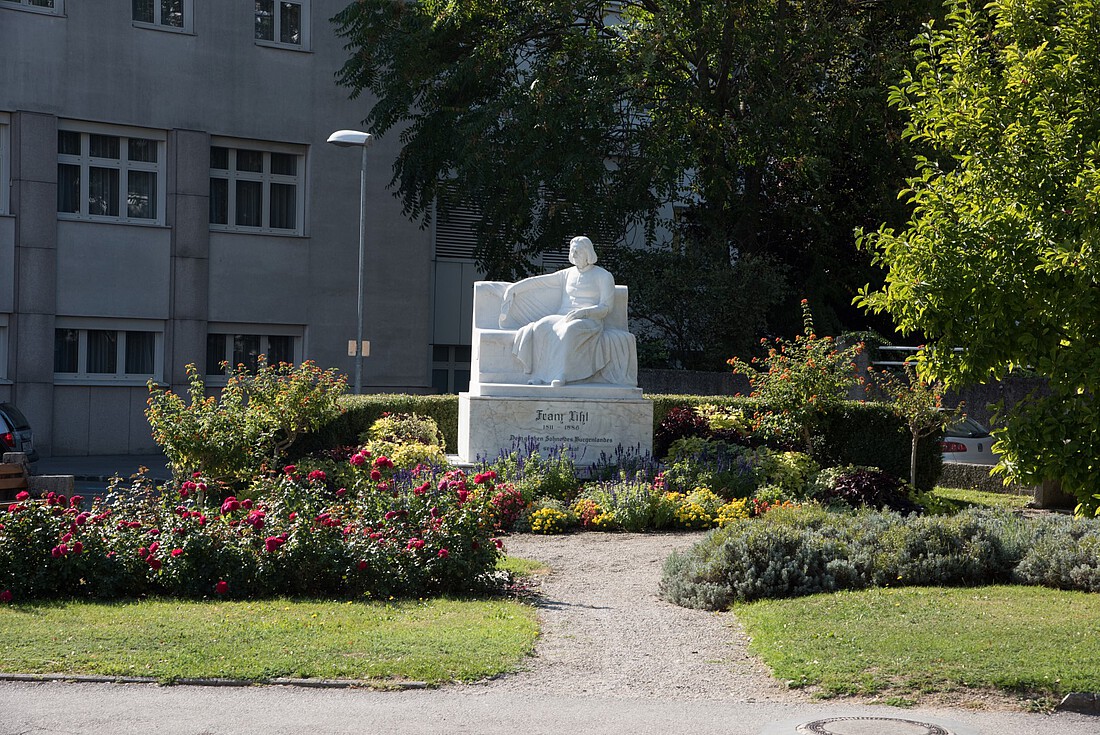 Denkmal Franz Liszt aus weißem Marmir umgeben von Sträuchern und Blumen