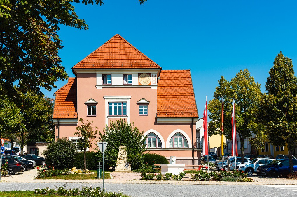 Haus mit dunkelrosa Fassade und mit einem Dachgiebel