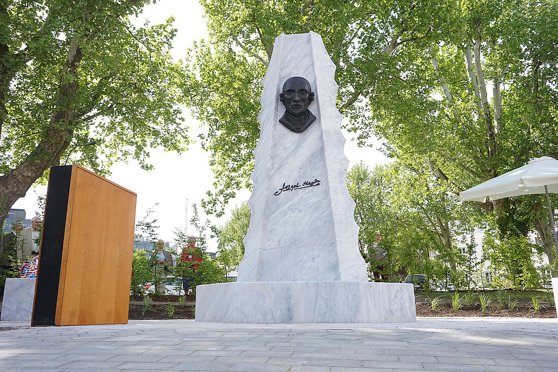 Hohes, quaderförmiges Denkmal aus weißem Marmor mit Bronze-Relieftafel