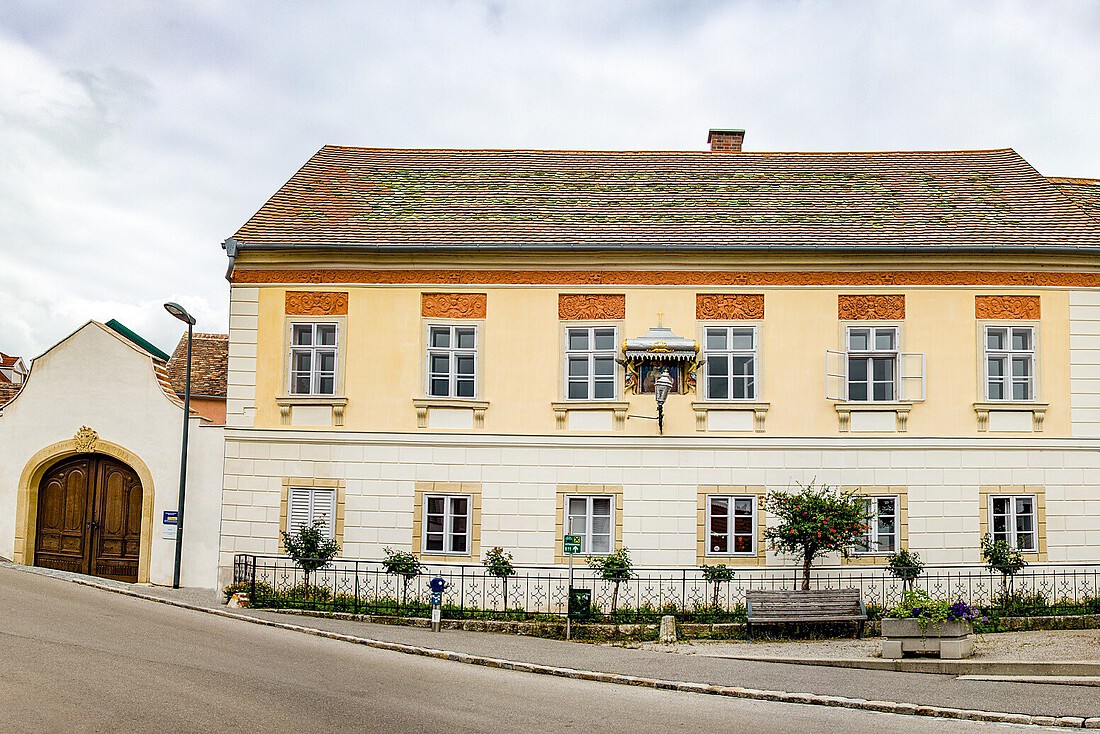 Gelbes, zweigeschossiges barockes Haus mit Marienbildnis an der Front
