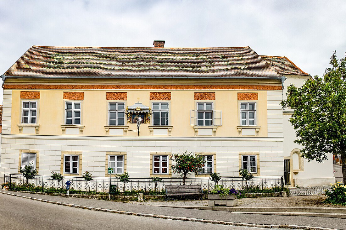 Gelbes, zweigeschossiges barockes Haus mit Marienbildnis an der Front