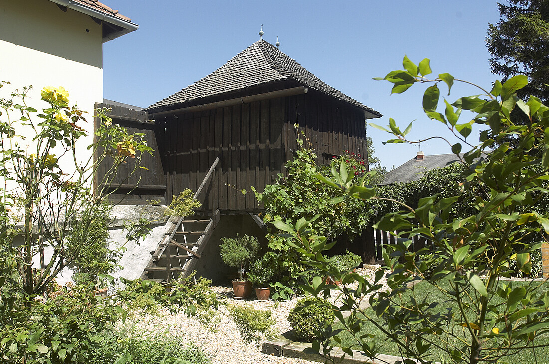 Kleines Holz-Gartenhausmit grünen Sträuchern